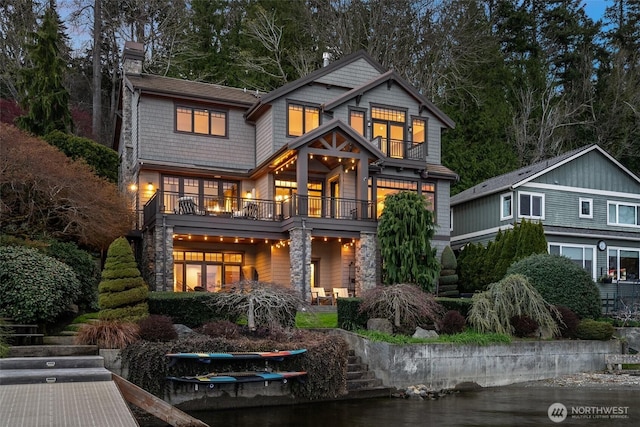 rear view of property with a chimney and a balcony
