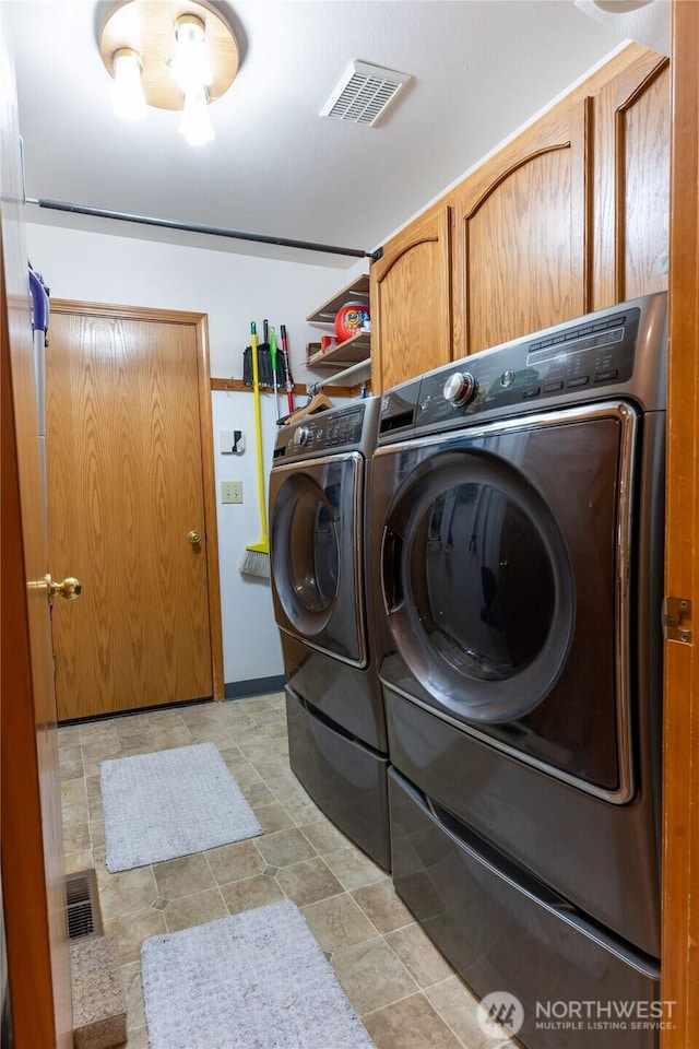 laundry room with visible vents, independent washer and dryer, and cabinet space