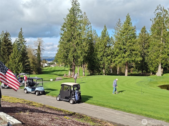 surrounding community featuring view of golf course and a lawn