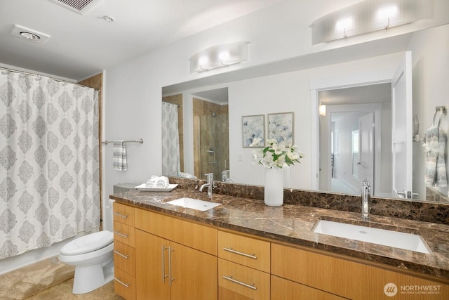 full bath with a sink, a shower with curtain, toilet, and double vanity