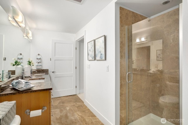 bathroom featuring double vanity, a sink, and a shower stall