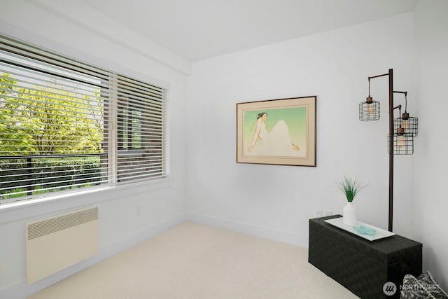 unfurnished room featuring a wealth of natural light, radiator heating unit, and carpet