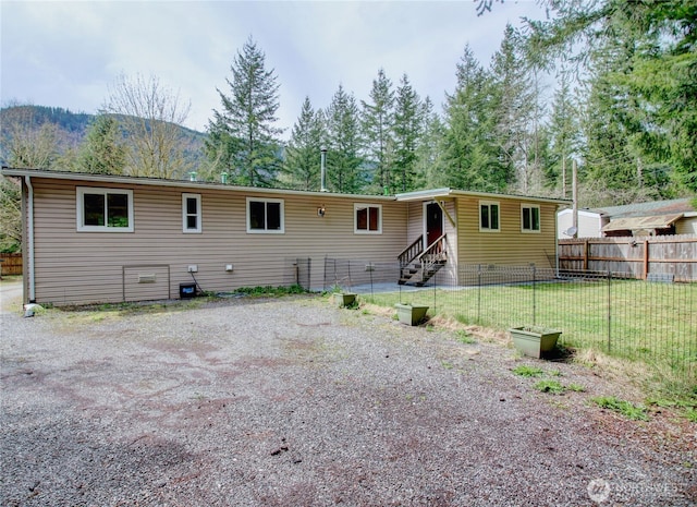 8095 Mosey Ct, Maple Falls, WA 98266 - back of house featuring entry steps, a mountain view, fence, and a lawn