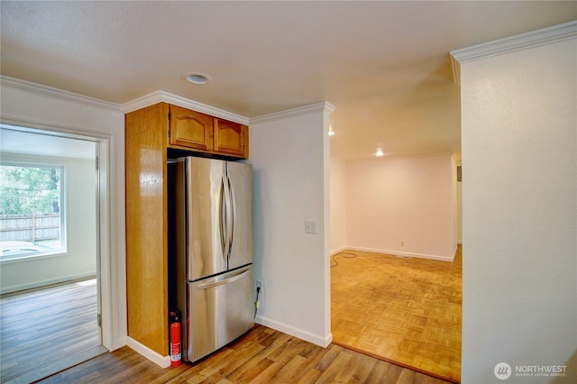 8095 Mosey Ct, Maple Falls, WA 98266 - kitchen with crown molding, freestanding refrigerator, baseboards, and light wood-style floors