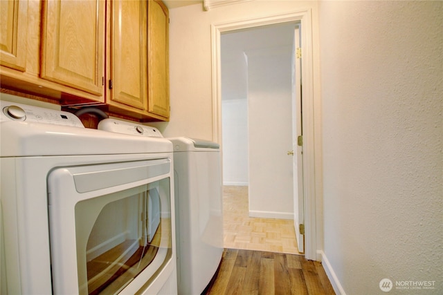 8095 Mosey Ct, Maple Falls, WA 98266 - laundry room featuring washer and dryer, baseboards, wood finished floors, and cabinet space