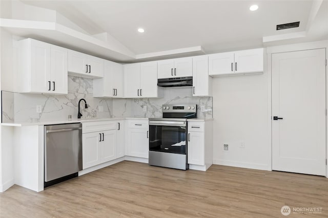 kitchen featuring visible vents, appliances with stainless steel finishes, light countertops, white cabinets, and under cabinet range hood