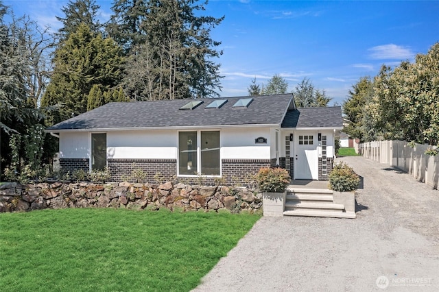single story home with brick siding, a shingled roof, a front lawn, and fence