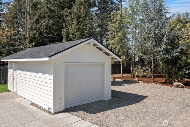 detached garage featuring fence