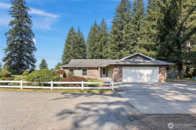 ranch-style house with a garage, brick siding, driveway, and fence