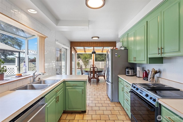 kitchen featuring a sink, light countertops, green cabinetry, and stainless steel appliances