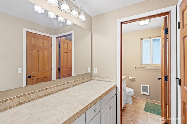 bathroom featuring vanity, tile patterned flooring, toilet, baseboards, and heating unit