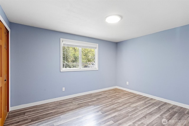unfurnished room featuring wood finished floors and baseboards