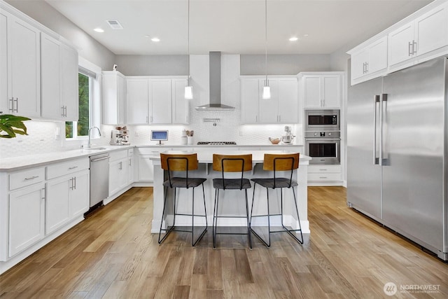 16216 81st Pl NE, Kenmore, WA 98028 - kitchen with built in appliances, wall chimney exhaust hood, a center island, decorative backsplash, and white cabinets