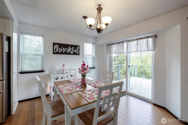 9365 Central Valley Rd NE, Bremerton, WA 98311 - dining area with a chandelier, a healthy amount of sunlight, wood finished floors, and baseboards