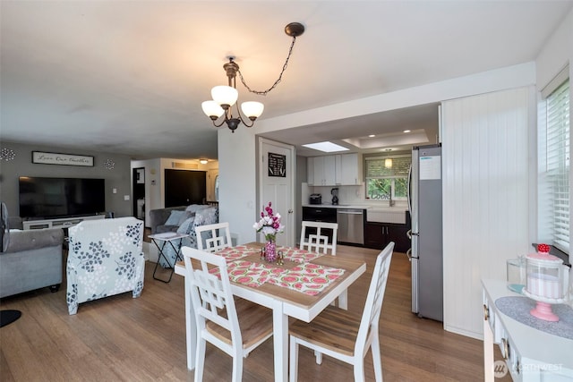 9365 Central Valley Rd NE, Bremerton, WA 98311 - dining space with wood finished floors and an inviting chandelier