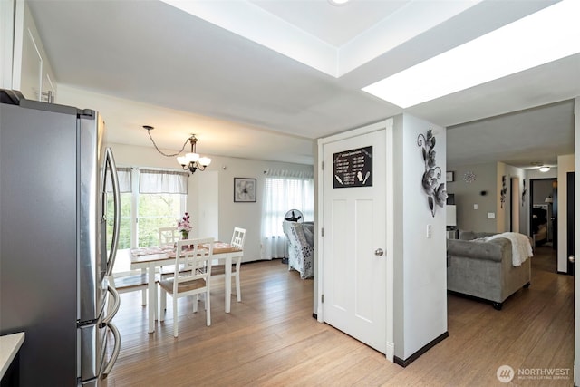 9365 Central Valley Rd NE, Bremerton, WA 98311 - interior space featuring a notable chandelier, baseboards, light wood-type flooring, light countertops, and freestanding refrigerator