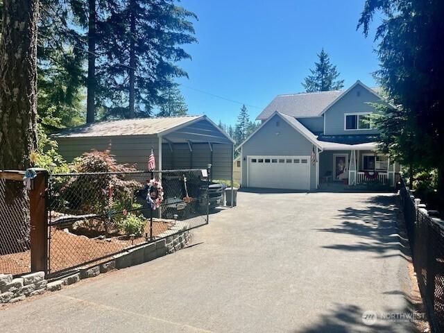 1921 NE Haven Way, Tahuya, WA 98588 - view of front of home with fence, a garage, covered porch, and driveway