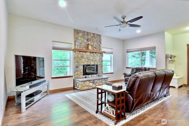 1921 NE Haven Way, Tahuya, WA 98588 - living area with a stone fireplace, ceiling fan, wood finished floors, and baseboards