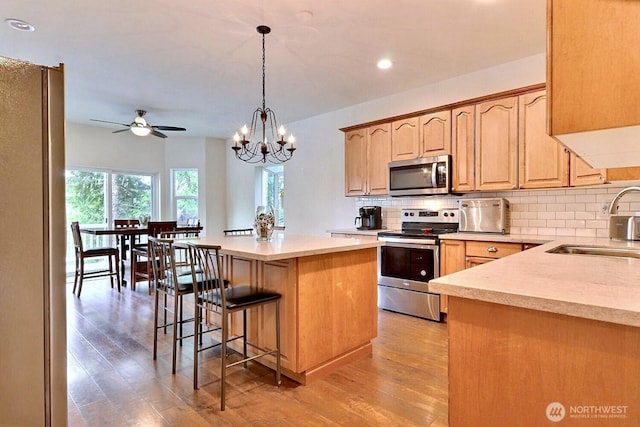 1921 NE Haven Way, Tahuya, WA 98588 - kitchen with a center island, light countertops, a sink, stainless steel appliances, and backsplash