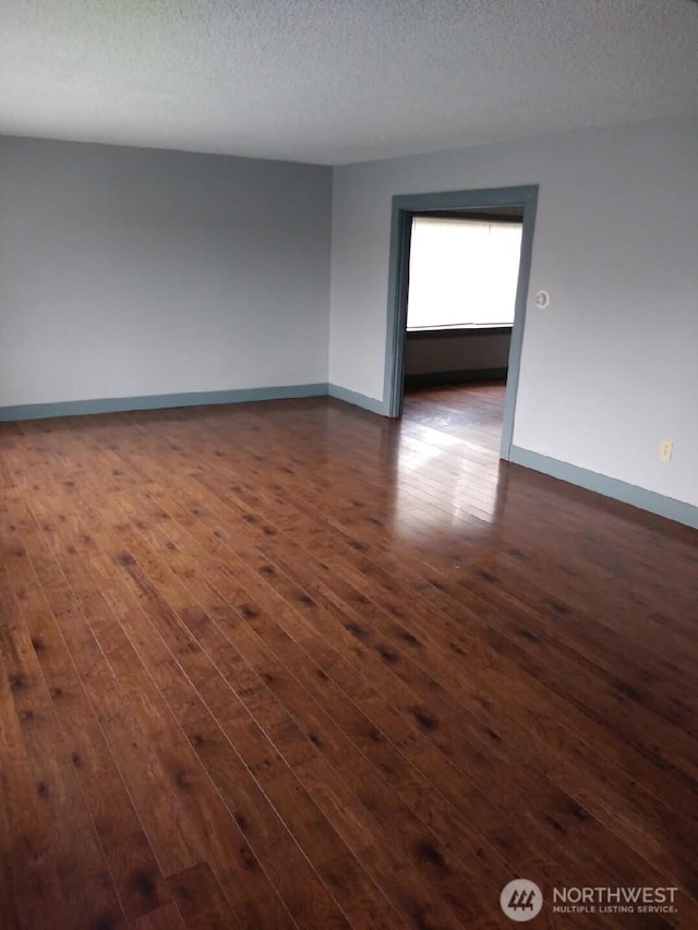 3025 Simpson Ave, Hoquiam, WA 98550 - unfurnished room featuring dark wood-type flooring, baseboards, and a textured ceiling
