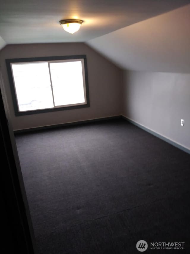 3025 Simpson Ave, Hoquiam, WA 98550 - additional living space with dark carpet, a healthy amount of sunlight, baseboards, and vaulted ceiling