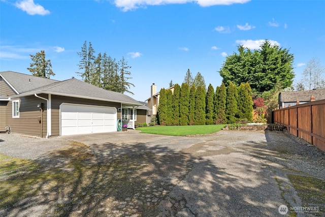 view of home's exterior featuring a garage, aphalt driveway, fence, and a lawn