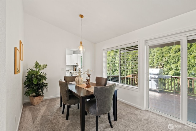 dining room featuring baseboards, vaulted ceiling, and light carpet