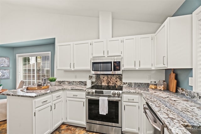 kitchen featuring a peninsula, white cabinetry, vaulted ceiling, and appliances with stainless steel finishes