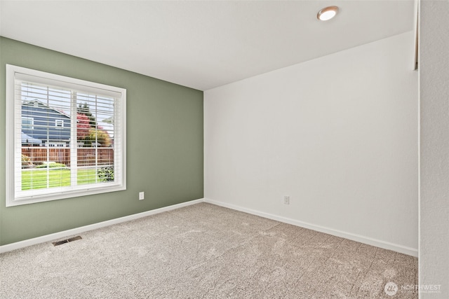 empty room with visible vents, baseboards, and carpet