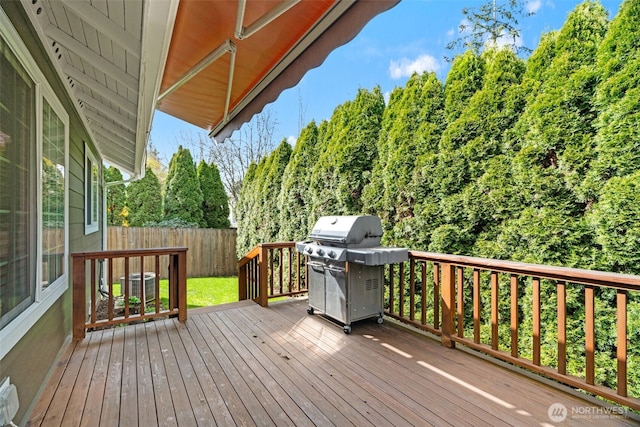 wooden terrace with a grill and fence