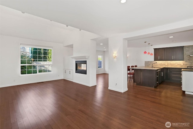 14026 SE 238th Ln, Kent, WA 98042 - unfurnished living room with a multi sided fireplace, a sink, baseboards, dark wood-type flooring, and recessed lighting