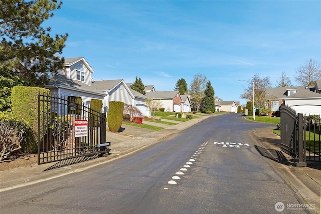 14026 SE 238th Ln, Kent, WA 98042 - view of road with a gate, a residential view, curbs, and street lights