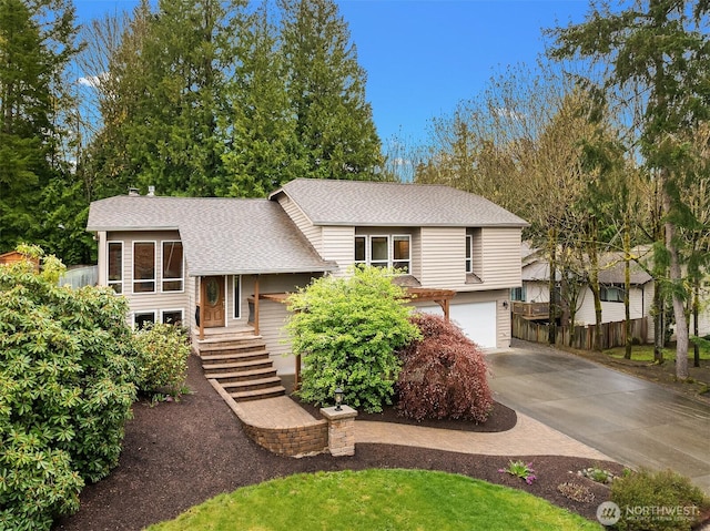 view of front of house featuring a shingled roof, driveway, a garage, and fence