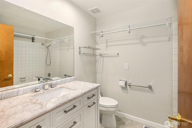 bathroom featuring visible vents, baseboards, walk in shower, toilet, and vanity