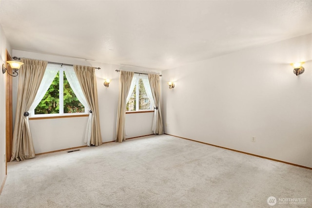 spare room featuring visible vents and carpet