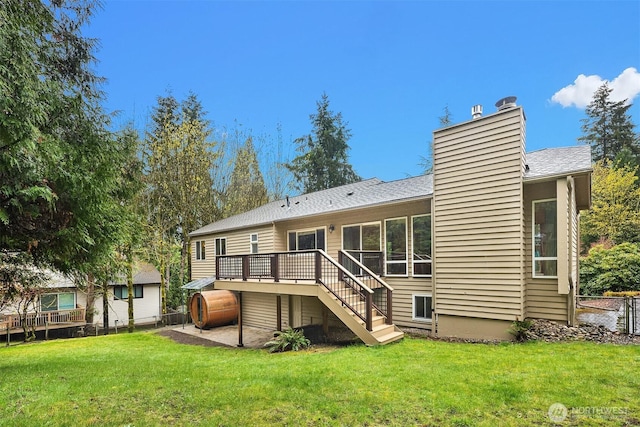 rear view of property with fence, a yard, a deck, and a chimney