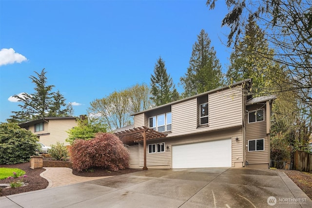 view of front of property with a pergola, a garage, and concrete driveway