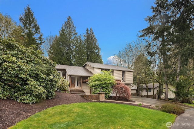 tri-level home with a front yard and concrete driveway
