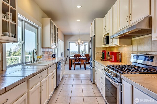 124 Hoods View Ct, Port Ludlow, WA 98365 - kitchen with appliances with stainless steel finishes, a sink, under cabinet range hood, tile countertops, and recessed lighting