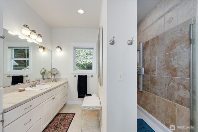 124 Hoods View Ct, Port Ludlow, WA 98365 - bathroom featuring a tile shower, vanity, tile patterned flooring, recessed lighting, and baseboards