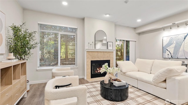 living room with recessed lighting, baseboards, a tiled fireplace, and wood finished floors