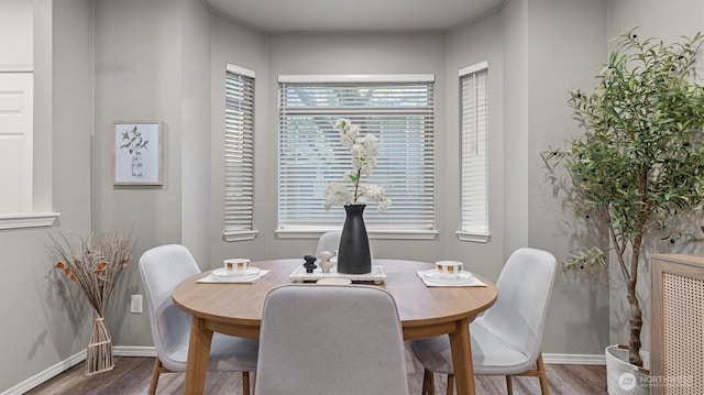 dining area with baseboards and wood finished floors
