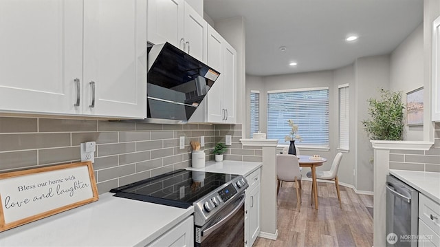 kitchen featuring baseboards, light countertops, white cabinetry, light wood finished floors, and stainless steel appliances