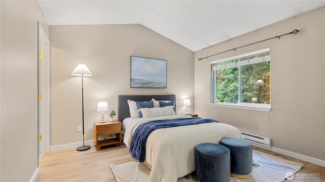 bedroom with light wood-style floors, baseboards, a baseboard heating unit, and lofted ceiling