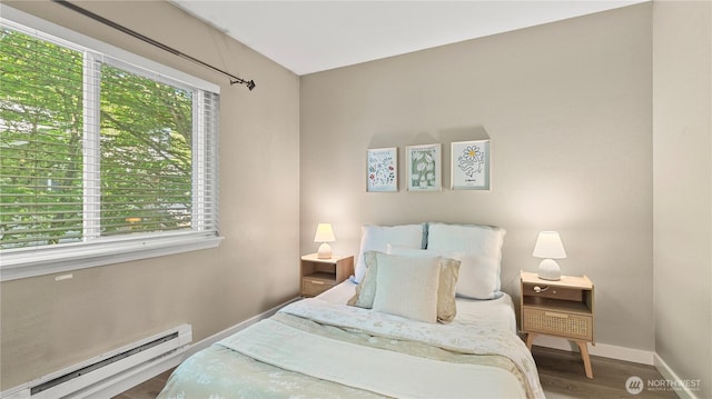 bedroom featuring baseboards, wood finished floors, and a baseboard radiator
