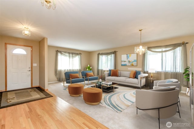 living area featuring baseboards, an inviting chandelier, and wood finished floors