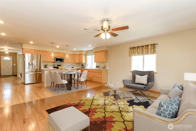living area with a ceiling fan, recessed lighting, a healthy amount of sunlight, and light wood-style flooring