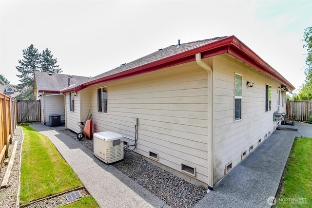 back of property featuring a fenced backyard and central AC unit
