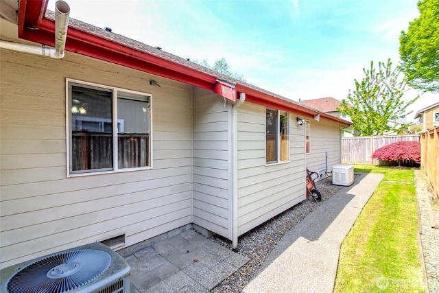 view of property exterior with fence and cooling unit