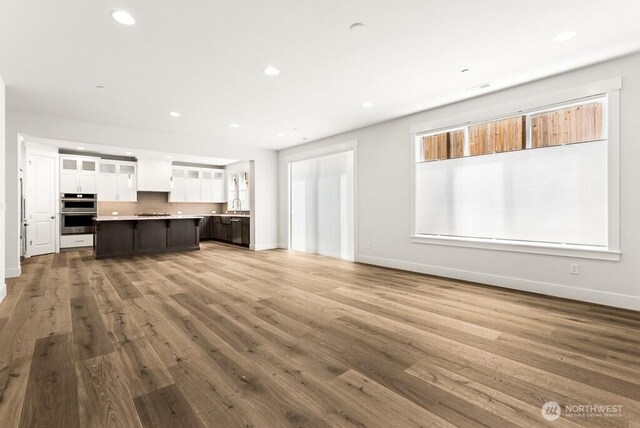 19512 81st Pl NE Unit 4, Kenmore, WA 98028 - unfurnished living room featuring recessed lighting and wood finished floors